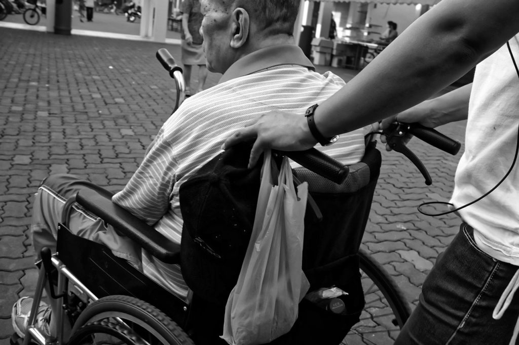 Family pushing man in wheelchair